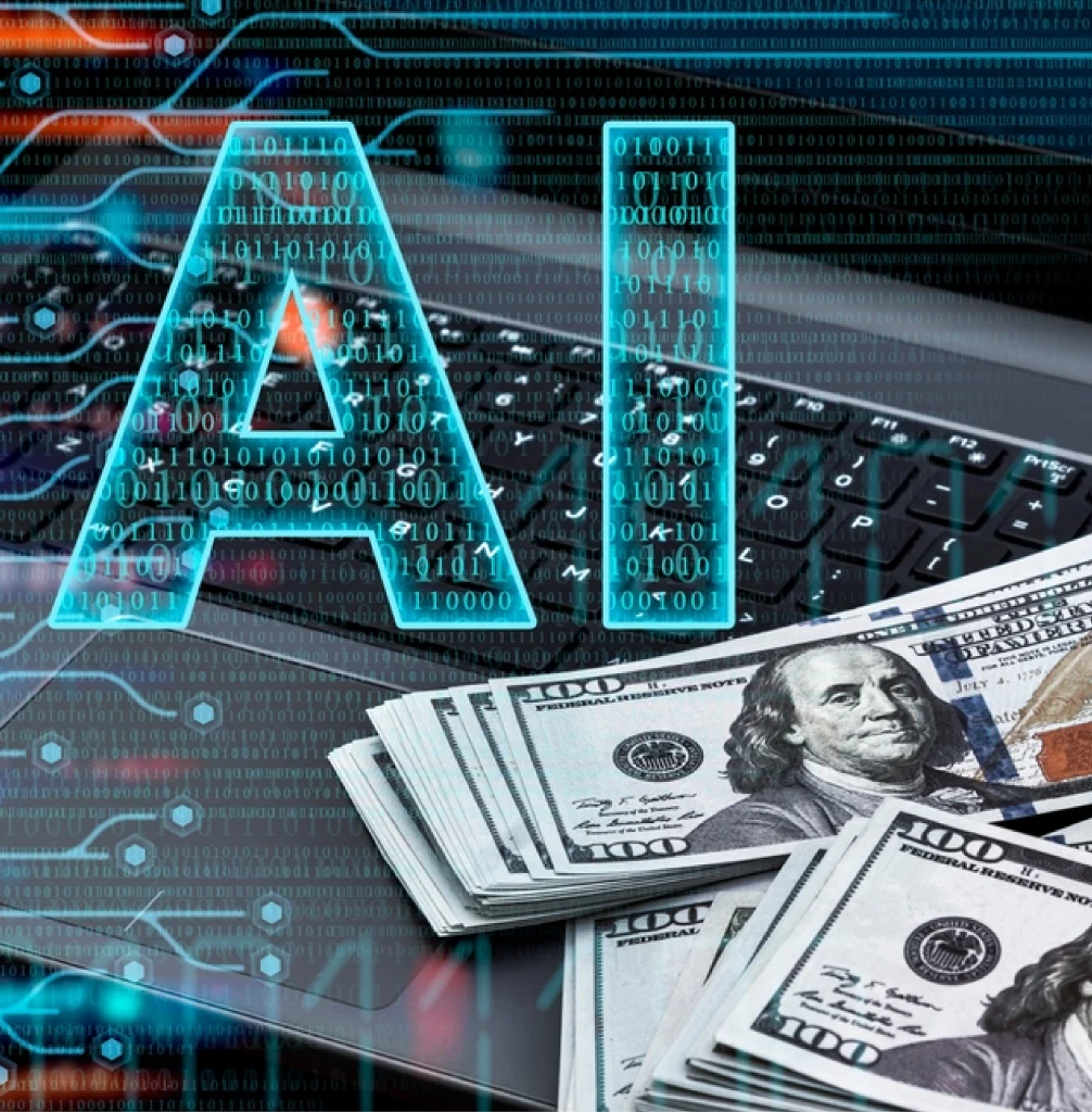 Digital image of "AI" text over a laptop keyboard with scattered U.S. dollar bills, suggesting the financial impact of artificial intelligence.