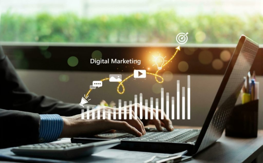 Person typing on laptop with glowing digital marketing icons like graphs and lightbulbs, showing innovation and strategy, representing digital marketing vs traditional marketing